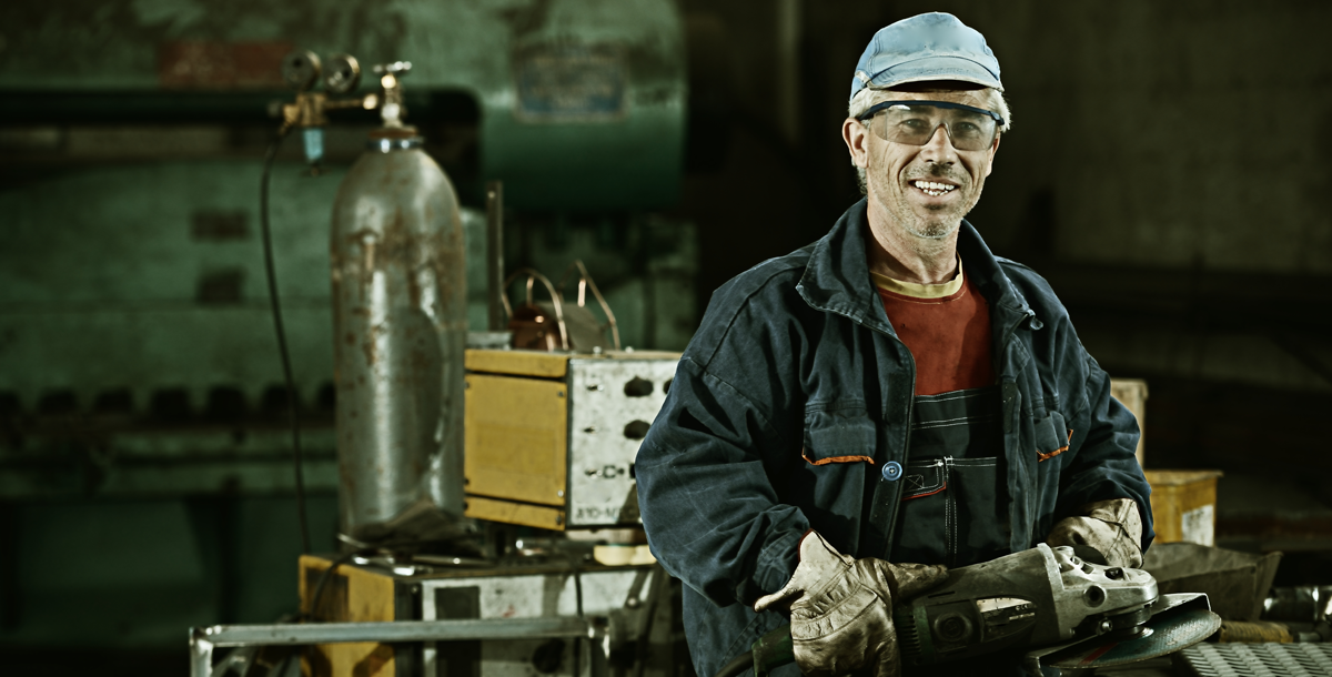 Photo of a steel worker with a metal grinder in their hands in a factory promoting micro-credentials.