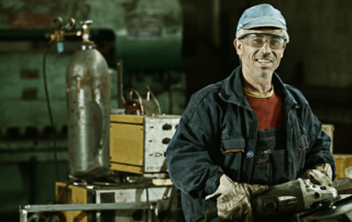 Photo of a steel worker with a metal grinder in their hands in a factory promoting micro-credentials.